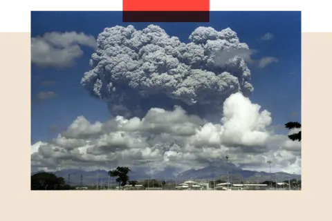 Getty Images Mount Pinatubo with enormous grey clouds above it against a blue sky following its eruption in 1991