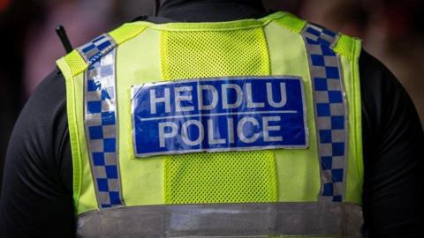 Welsh police uniform with the words Heddlu Police written on the back