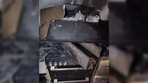 HIWFRS A cooker hood which has collapsed on to the hob below. It is burnt and covered in black soot.