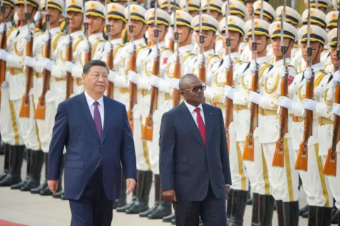 VINCENT THIAN/GETTY IMAGES Umaro Sissoco Embalo, the president of Guinea-Bissay, inspects troops at the Great Hall of People in Beijing. Walking next to him is China's President Xi Jinping.