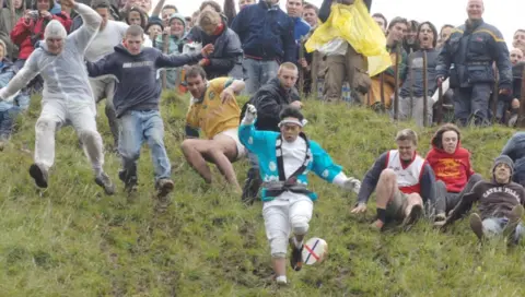 People taking part in cheese rolling in Gloucestershire 
