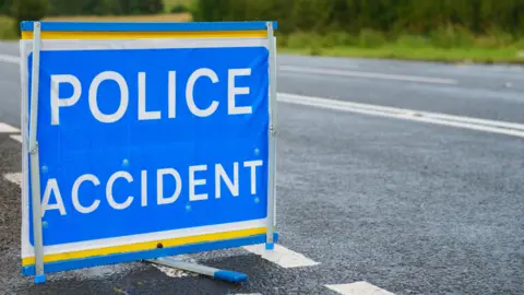 A blue sign at the side of the road that reads police accident in white capital letters.