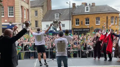 James Burridge/BBC Saints players lift the Premiership trophy to the fans in Northampton