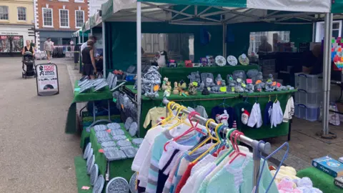 A series of market stalls selling jumpers, books, ornaments and vinyl.