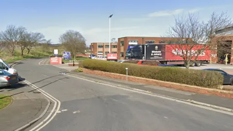 The end of Plymouth Road, which cut through an industrial estate with cars parked either side and a delivery lorry on a car park to the right