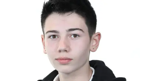 A close up image of Stefan Kluibenschadl, aged 15, looking to camera wearing a dark jacket. He has both his ears pierced. 