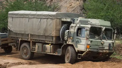 British army MAN support truck navigates its way through rough terrain 