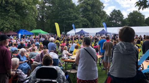 A large crowd of people gathered near a marquee at the 2023 Disability Awareness Day
