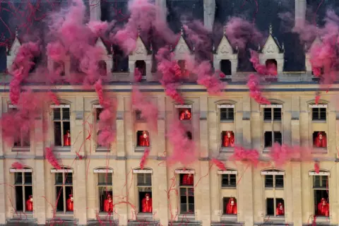   Bernat Armangué/AP Smoke billows near windows as performers participate during the opening ceremony of the 2024 Summer Olympics