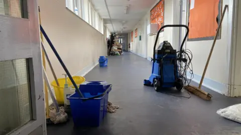 Buckets and cleaning machines in school corridor