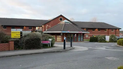 A single-storey building with a large driveway.