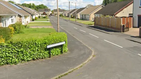 A quiet cul de sac with bungalows and long grass drives. A sign reads: Brockenhurst Drive.