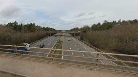 Looking down on the M5 at junction nine from a bridge with vehicles passing underneath