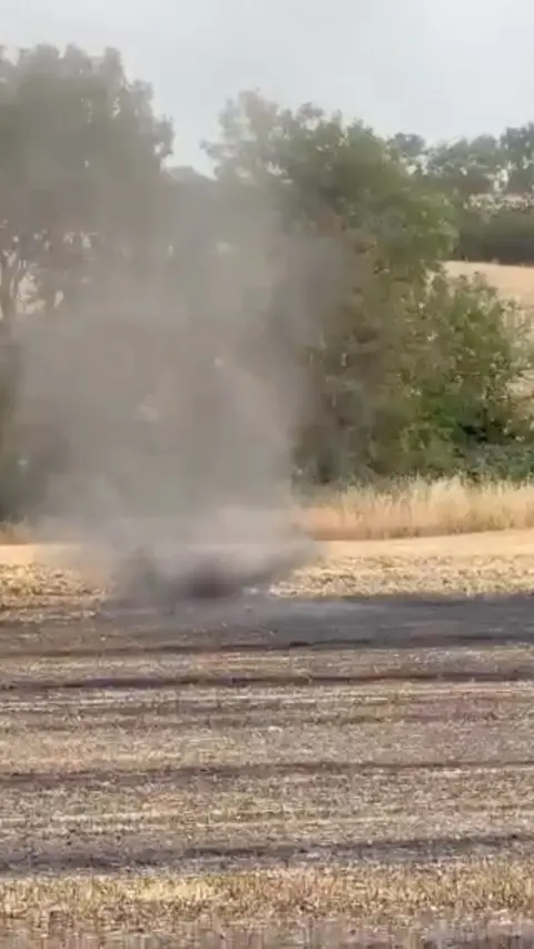 A small whirlwind swirls on a newly harvested field