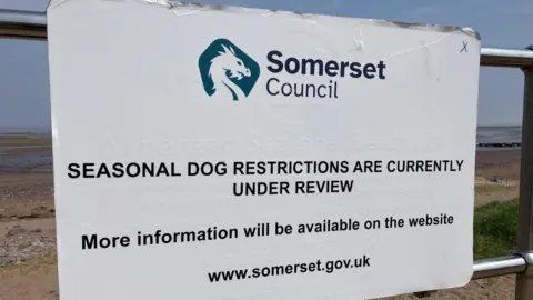 A warning sign about seasonal dog restrictions