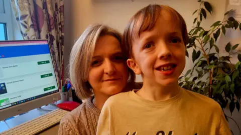 Wendy and Andrew Gallagher - Wendy has short bobbed blond hair and is wearing a light jumper and Andrew, her young son, has light brown hair and is wearing a long sleeve t-shirt