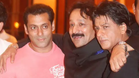 Mbunge wa Bunge la Getty Images Baba Siddique akiwa na waigizaji wa Bollywood Salman Khan na Shah Rukh Khan kwenye karamu yake ya iftaari Taj Lands end, Bandra mnamo Julai 21, 2013 mjini Mumbai, India. Shah Rukh Khan na Salman Khan walipigana mwaka wa 2008 katika sherehe ya kuzaliwa kwa Katrina Kaif huko Olive.