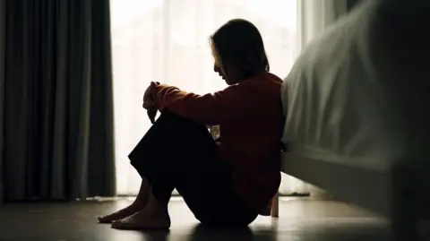 Woman in silhouette on bedroom floor