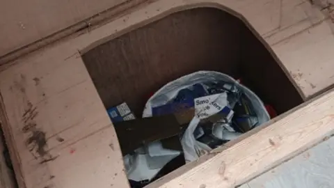 Worcestershire Regulatory Service A hole in the floor reveals items in a plastic bag.