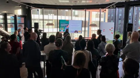 The launch event for the Home fostering agency with people gathering in a room.