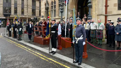 The silence was observed outside of Town Hall in Inverness as young cadets in formal military attire stood with various fla