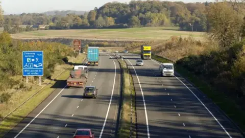 PA Media A view from a bridge over the A34 dual carriageway. Lorries and cars drive either way to and from the camera, with green grassy banks on either side