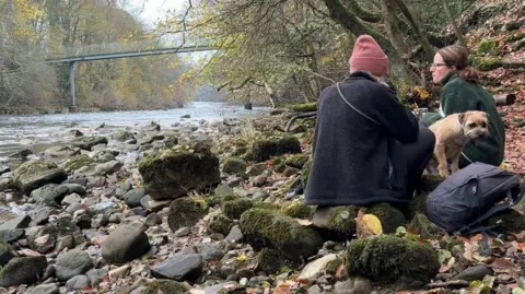 Two women on a riverbank