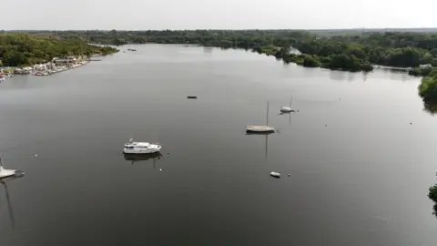 An aerial shot of Wroxham Broad showing two yachts in the middle of the broad