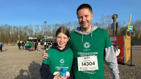 L-R Lyla and Matt Wise in green t-shirts for the Green Park Challenge are both smiling at the camera.