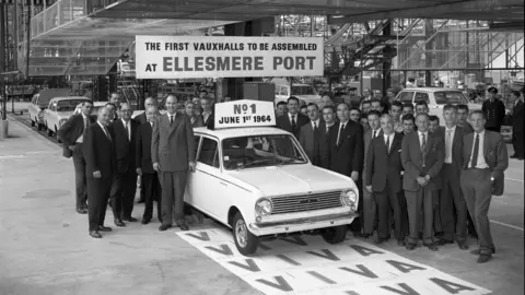 Stellantis Staff pictured in 1964 standing next to the Vauxhall Viva on the production line at the Ellesmere Port factory 