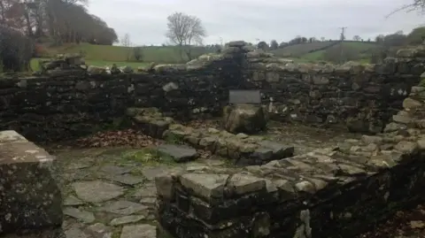 The ruins of an old stone cottage, photographed on a cloudy day