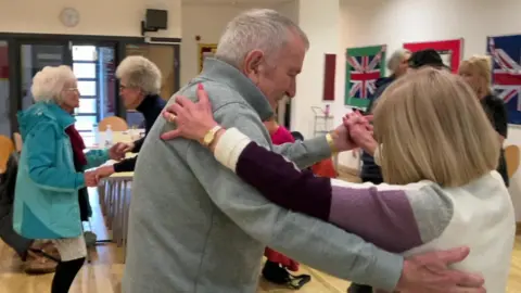 Image of two group members dancing together during one of the music sessions 