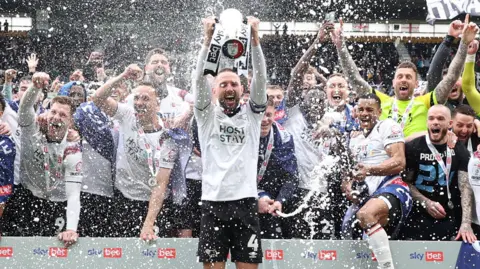 Conor Hourihane lifts the League One trophy