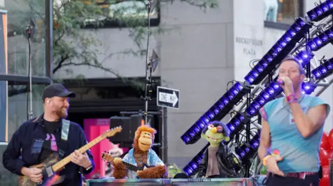 Reuters Coldplay and a few Muppets perform on stage on an American street