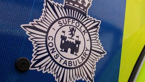The badge for Suffolk Constabulary on the side of a car.