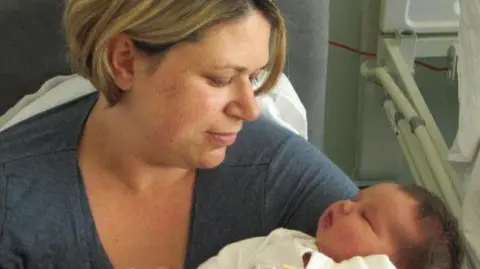 Family Handout Nikki with her daughter in her arms in hospital