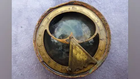 Steven Ellis An round bronze sundial compass with numbers on a thin outer circle of bronze