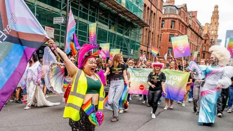 Parade goers participate in the Manchester Pride 2025 Parade on August 23, 2025