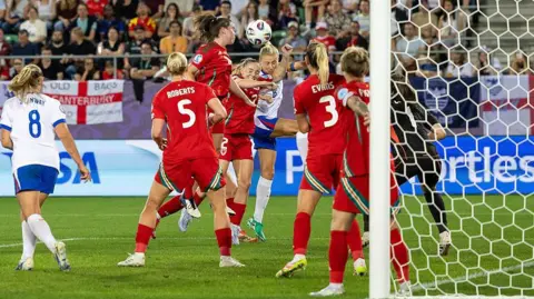Getty Images Lily Woodham of Wales (L) fights for heading the ball with Leah Williamson of England (R) during the UEFA Women's EURO 2025 Group D match between England and Wales at Arena St. Gallen on July 13, 2025 in St Gallen, Switzerland.