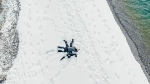 BBC/Studio Lambert Kush lies on top of Jo who is spreadeagled on ice in Hatgal, Mongolia.