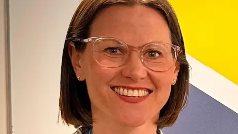 Derbyshire Police A head shot of a woman with shoulder-length brown hair and glasses.