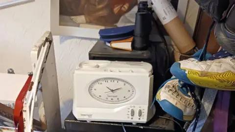 Restore/Leslie Midwinter A picture of clutter in a home. A clock, a pair of shoes, a pair of binoculars and other items can be seen. 