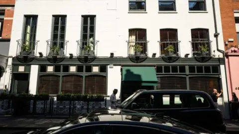 Getty Images The outside of the Groucho Club in London. It is a white building with balconies protruding from the upstairs windows. Two black cabs are parked outside.