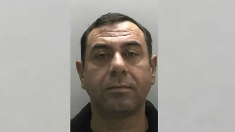 A police mugshot of Neclp Uslu