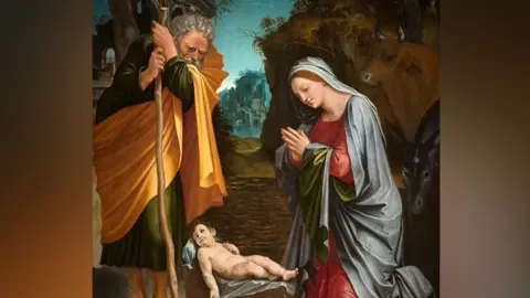 The National Gallery, London A painting of the nativity scene. A woman is kneeling to pray. A man who a staff in his hand is standing beside her, wearing a yellow cape. A cow and castle appear in the background 