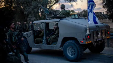 EPA Israeli soldiers on a road near Kibbutz Be'eri, southern Israel (11 October 2023)