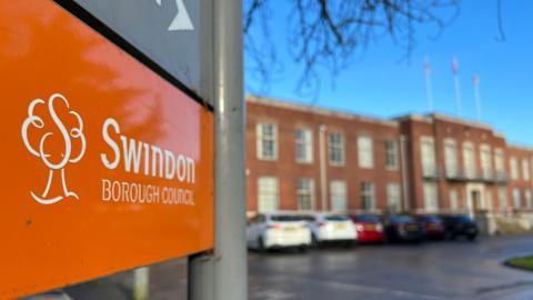A sign coloured orange with Swindon Borough Council typed out in white