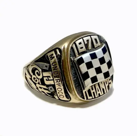Gildings Auctioneers A gold and black signet ring with the words '1970 CHAMPS' on the front with the name 'M.UNDERWOOD' on the side.