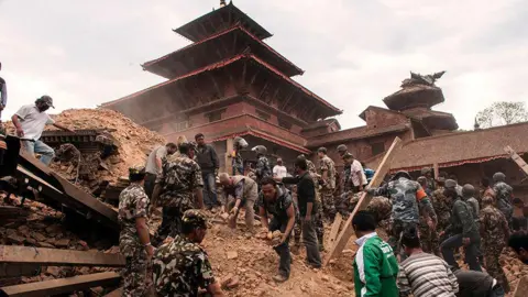 PA Media Aftermath of the 2015 earthquake in April. Teams of soldiers and civilians can be seen moving rubble from the entrance of a temple.