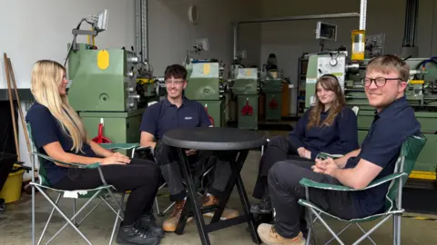 Ben Schofield/BBC Four people sitting around a round table. Hope Hayden-Ferguson is on the left, next is Myles Dillon, then Tegan Smith and Will Harris-Aebvtivs is on the right. They are all wearing dark blue tops, 
